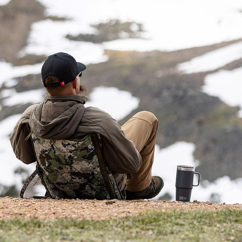 Load image into Gallery viewer, Man sitting in a camo chair on a snowy mountainside