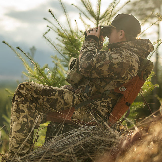 Load image into Gallery viewer, Man dressed in camo looking through binoculars while sitting in a copper hex chair