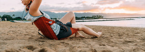 A woman relaxing and leaning back in her comfy chair on the beach at sunset