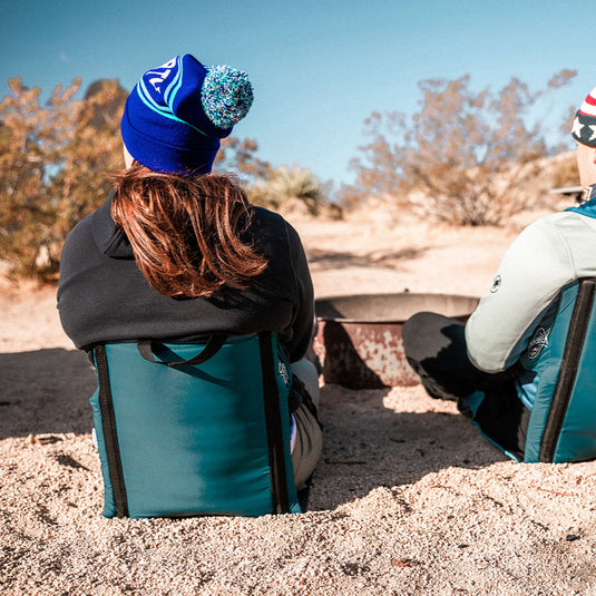 Woman sitting in a casual chair next to a fire pit in the desert